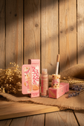 Kevin & Coco Skin-Like Finish Concealer in a pink and beige 'Cotton Candy' shade, shown with its pink packaging, applicator wand, and tube on a dark desk.